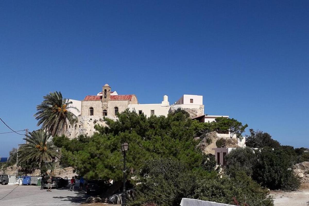 um edifício no topo de uma colina com uma palmeira