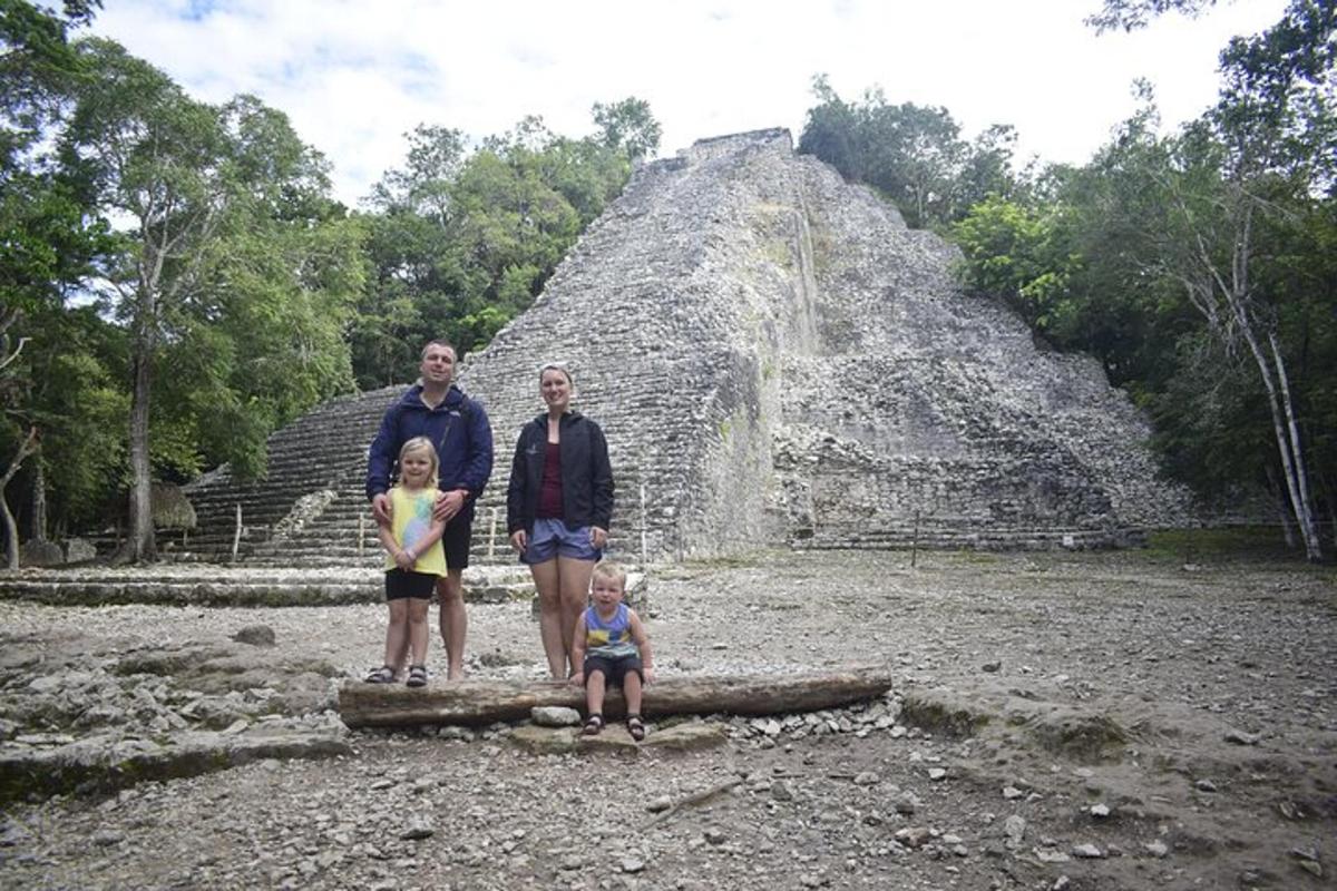 a family standing in front of a pyramid