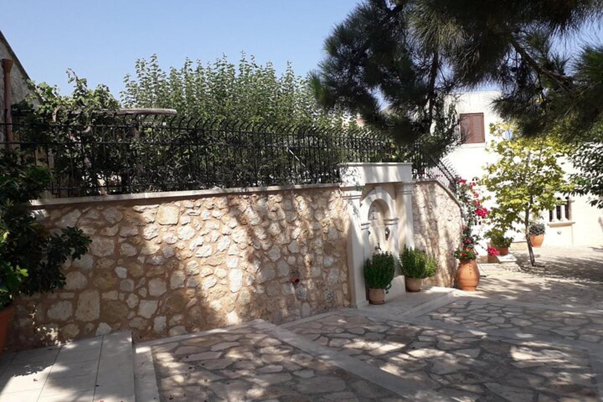un muro di pietra con piante in vaso e una recinzione