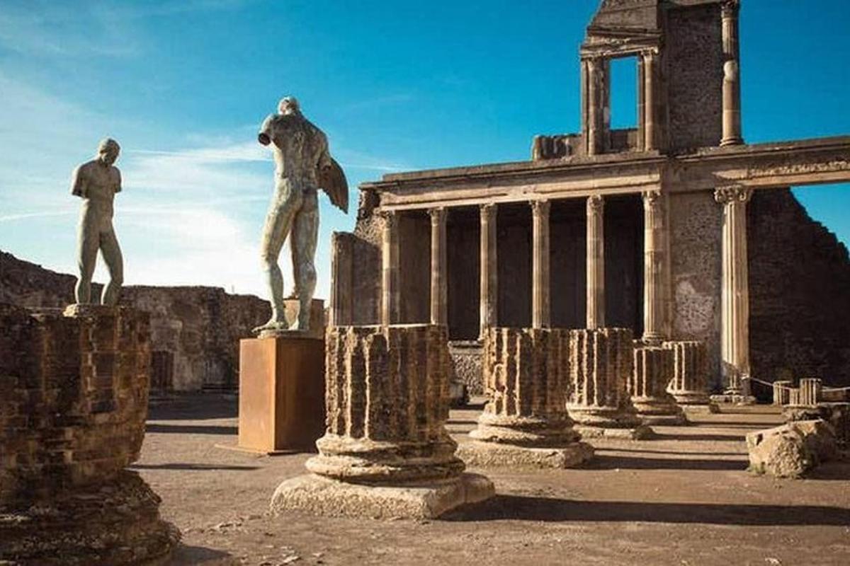 uma estátua de um homem em pé sobre um pedestal em frente a um edifício