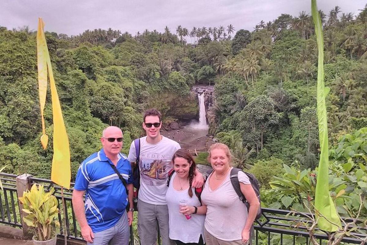 un gruppo di persone in piedi davanti a una cascata