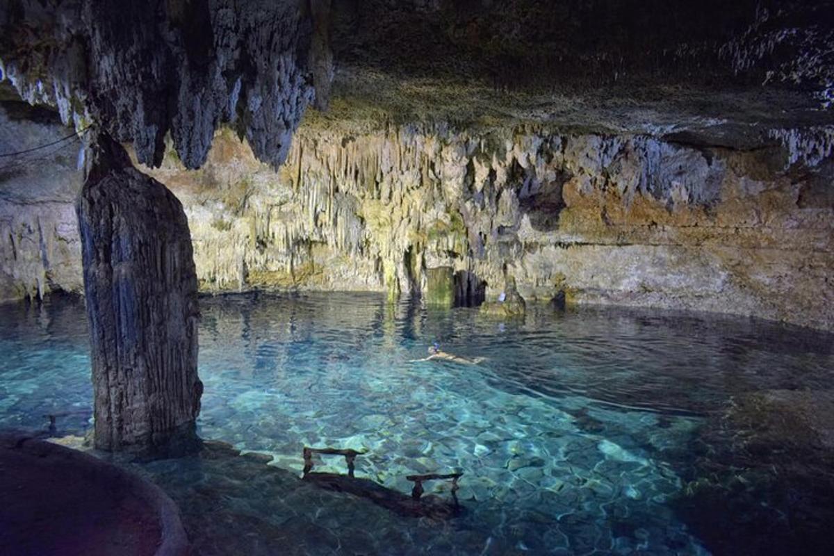 a person swimming in a pool in a cave