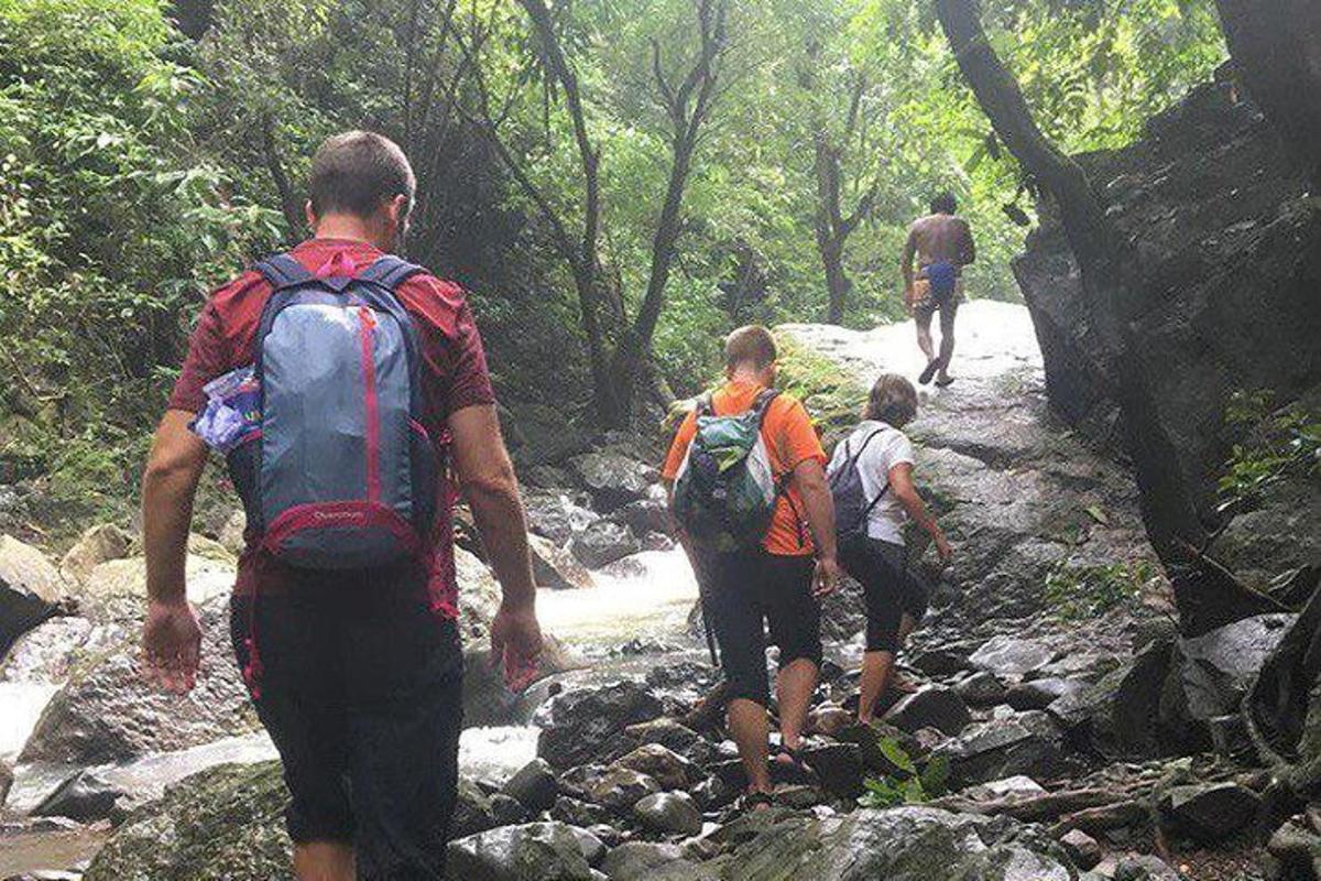 um grupo de pessoas caminhando por uma trilha rochosa