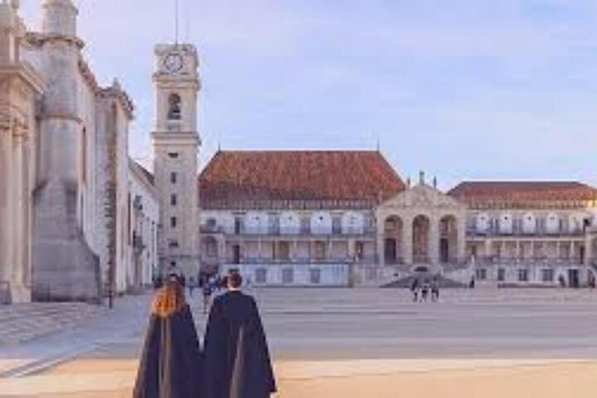 dve osebi, oblečeni v črno, stojita pred stavbo