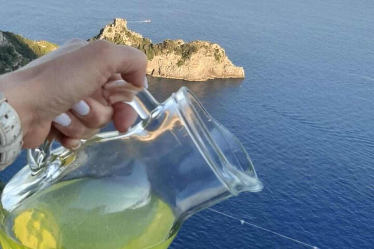 una mà que sosté un pot de vidre amb vistes a l'oceà