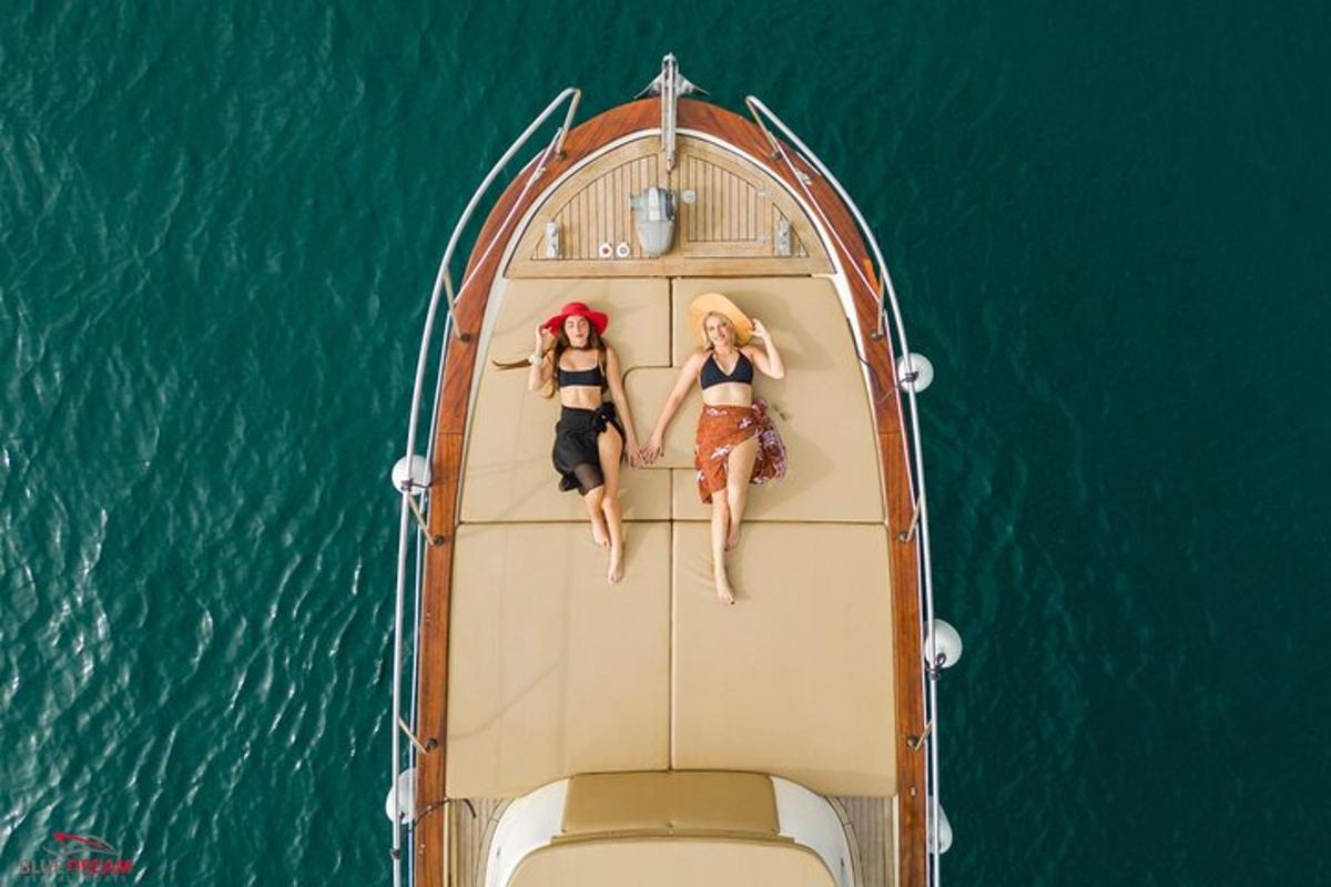 due donne sedute sul retro di una barca in acqua