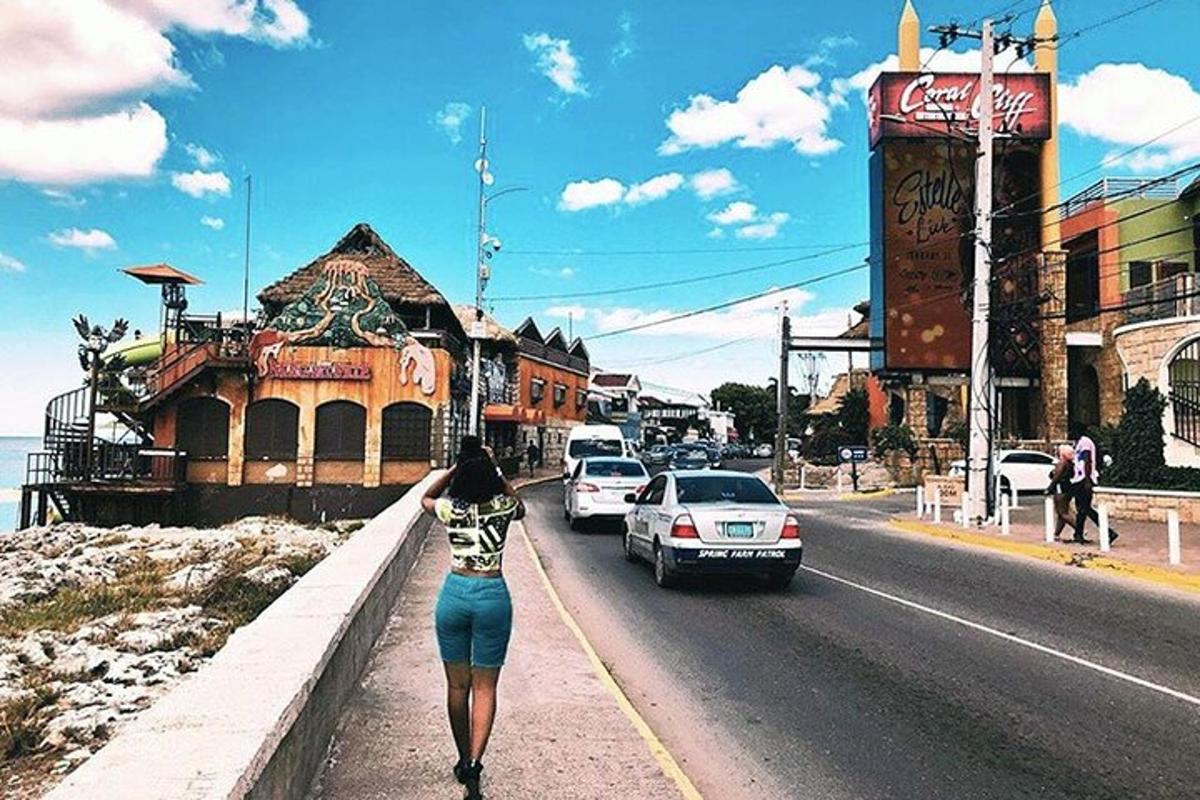 seorang wanita berjalan di kaki lima di sebelah jalan