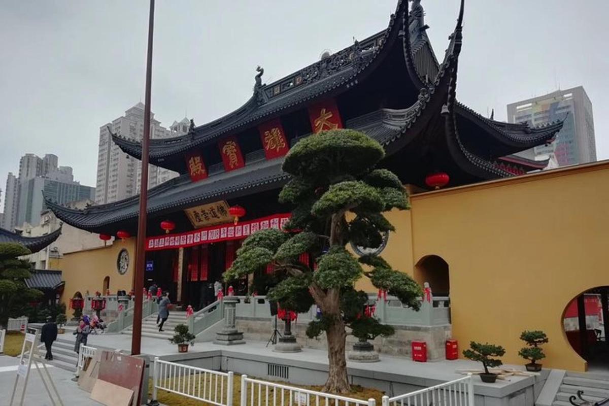 Un gran edificio con un árbol delante.