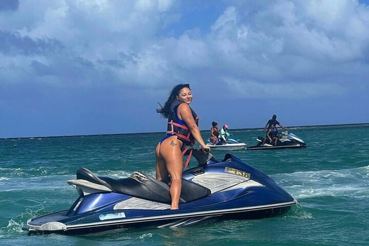 žena v bikinách jedoucí na vodním skútru v oceánu