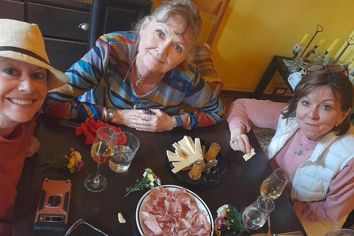 en gruppe på tre kvinner som sitter ved et bord med mat