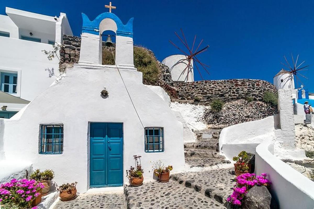 uma igreja branca com uma porta azul e flores