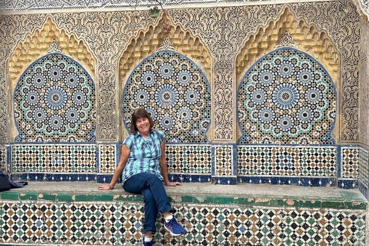 a person sitting on a bench in front of a wall