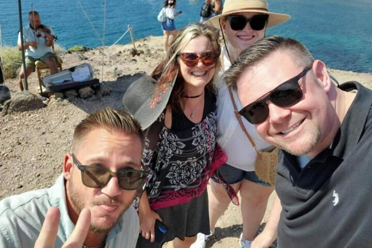 hópur fólks að pósa fyrir mynd á ströndinni