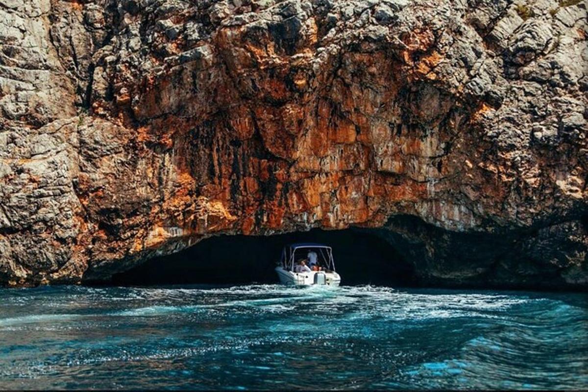 một chiếc thuyền trên mặt nước trước một hang động
