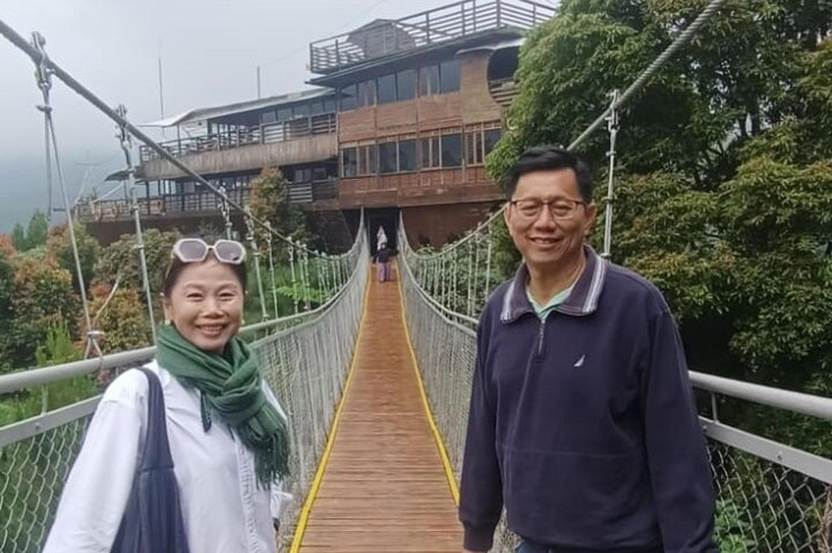 twee mensen staan op een hangbrug