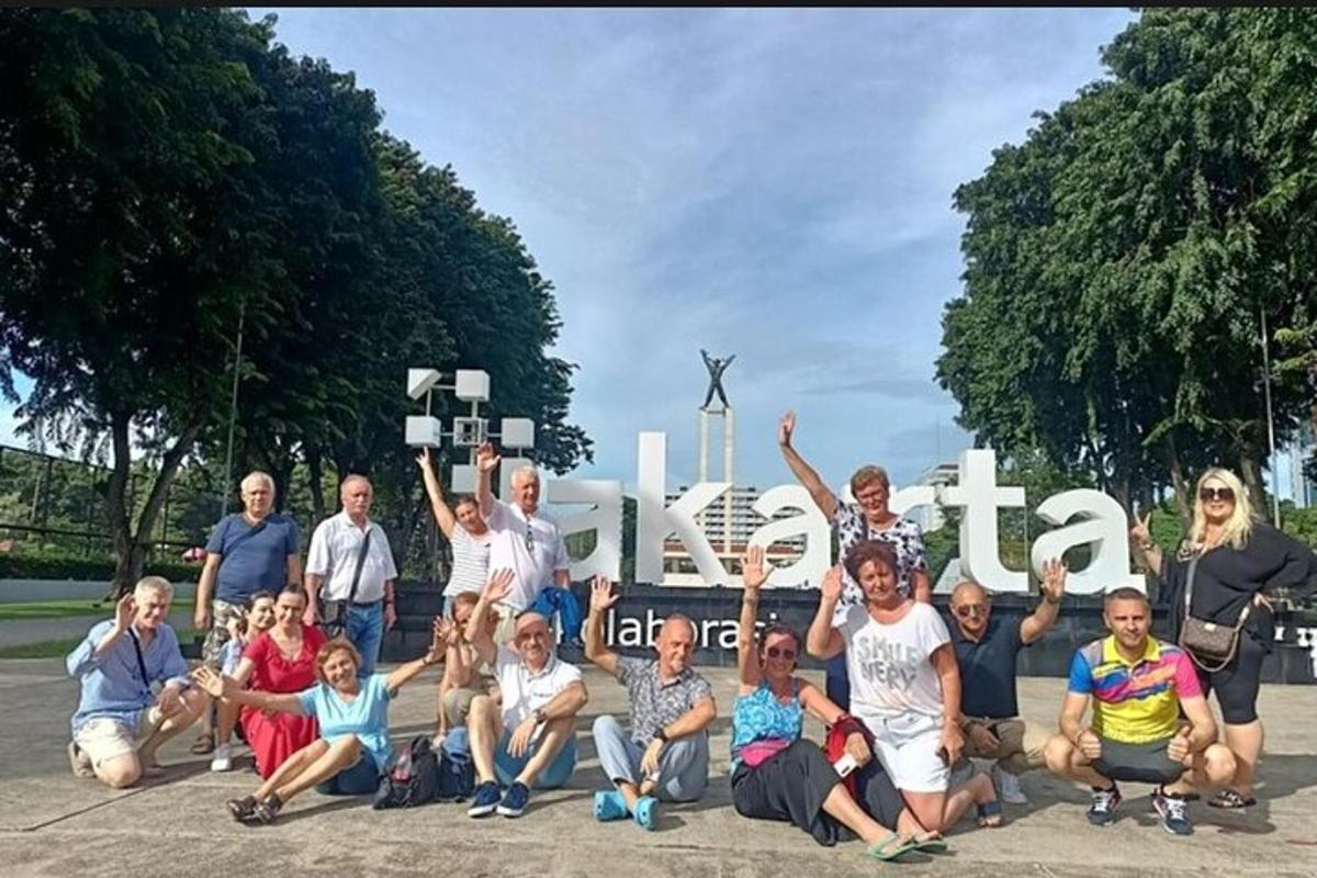 un grup de persones posant per a una foto davant d'un rètol