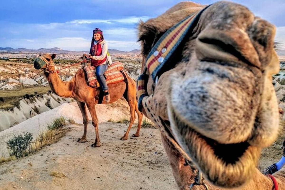 uma mulher montada em um camelo no deserto