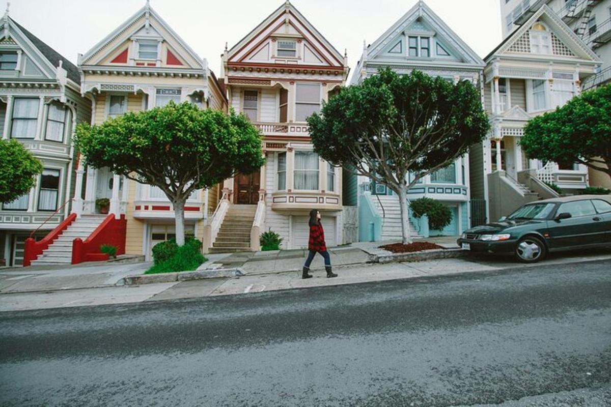 Una mujer caminando por una calle frente a las casas.