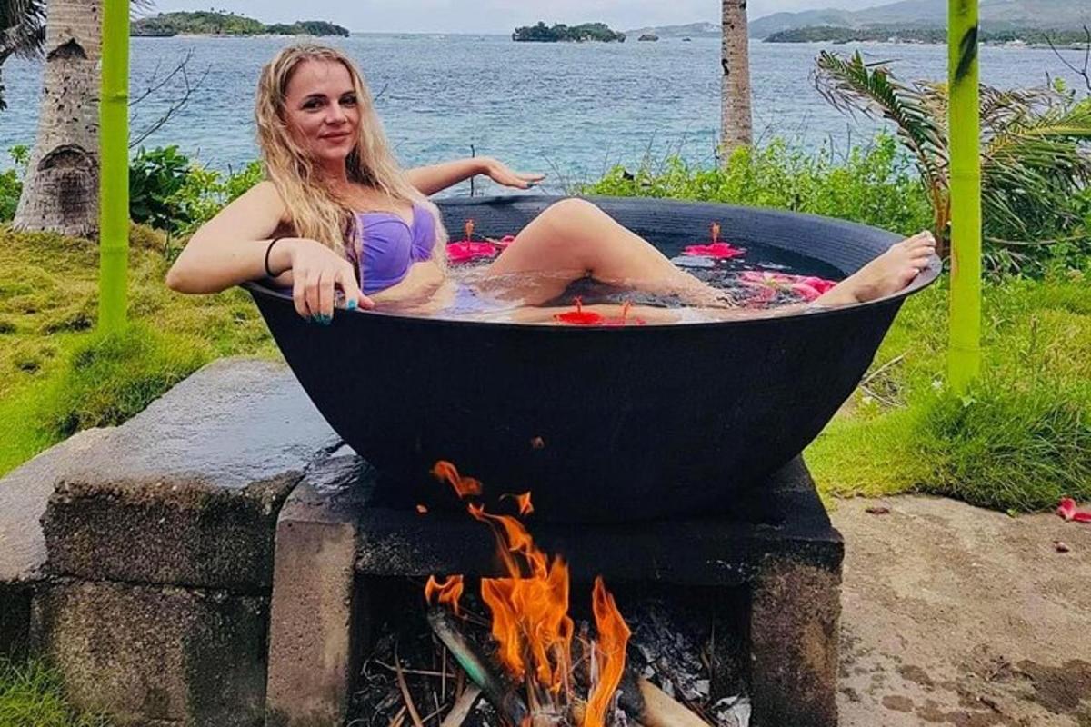 a woman sitting in a bath tub over a fire