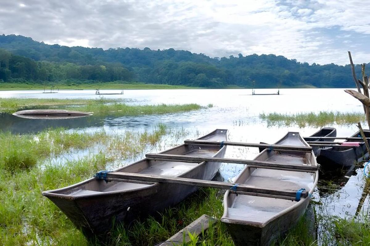 tiga perahu duduk di tepi danau