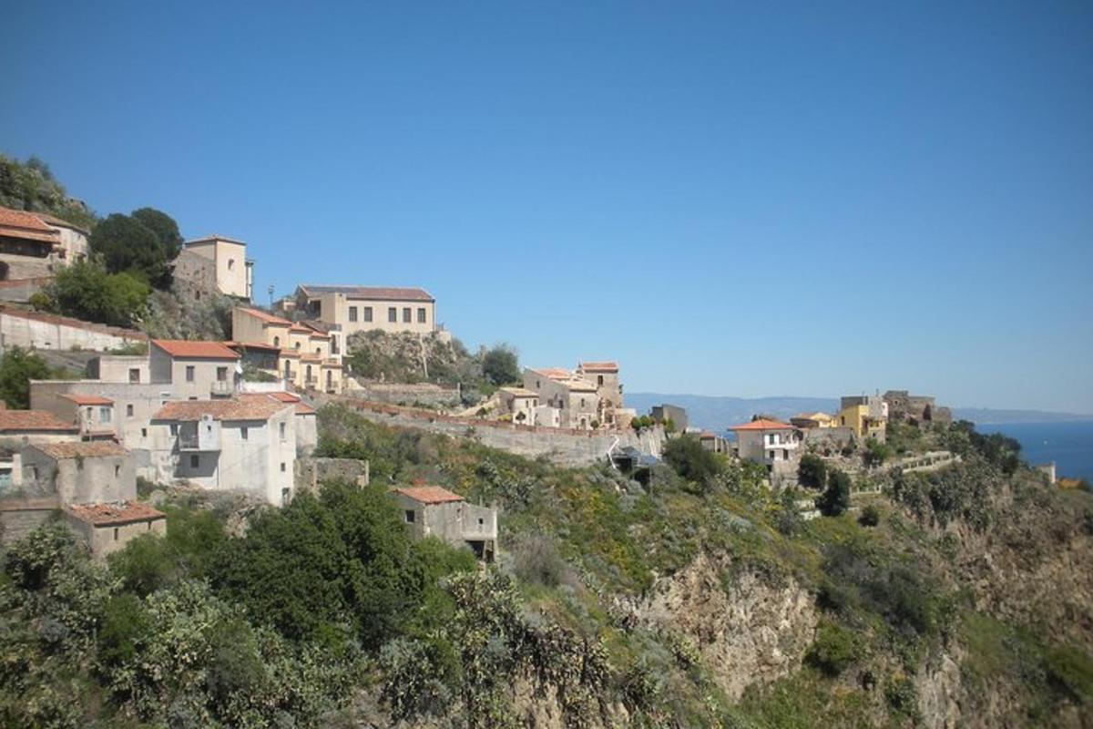 un gruppo di case su una collina con l'oceano