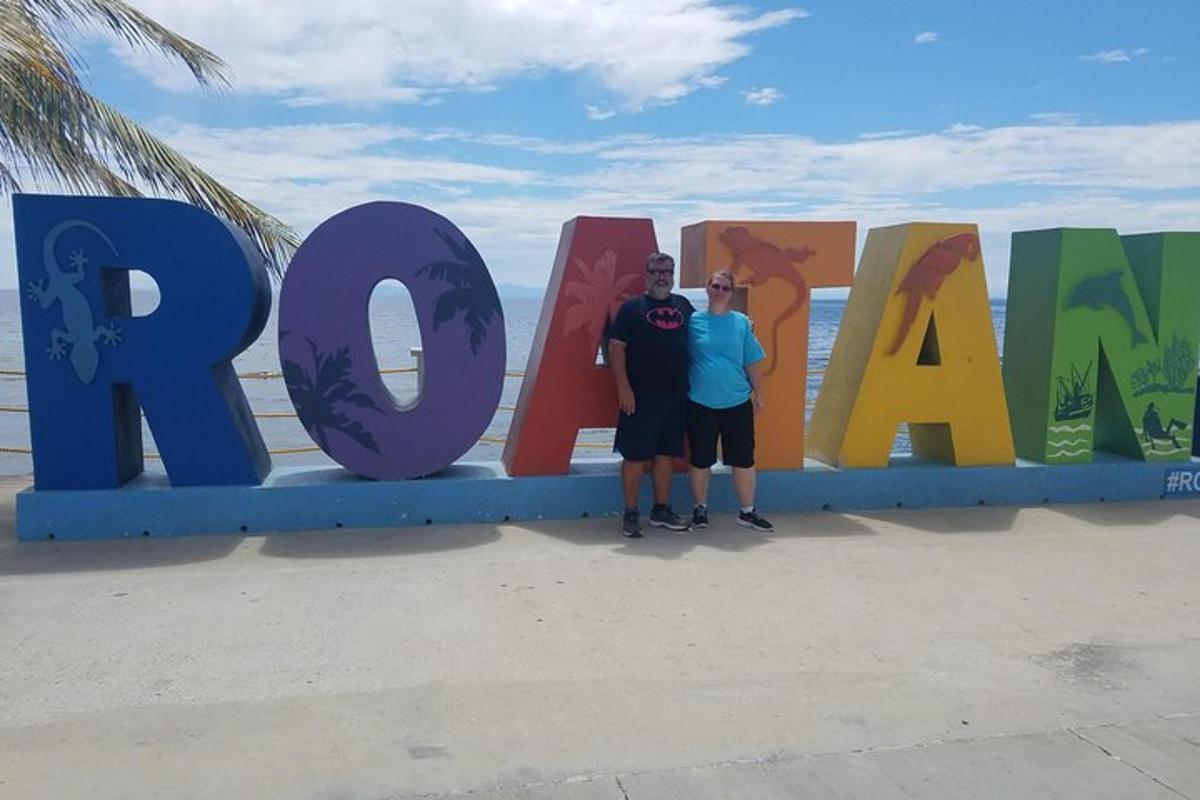 two men standing in front of a large sign for the beach