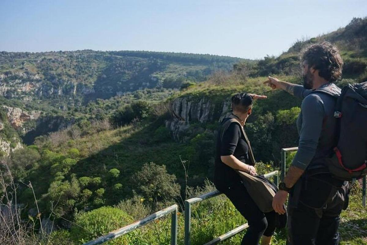 dva lidé stojící na vrcholu hory a dívající se na údolí