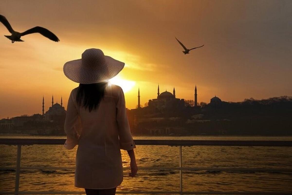 a woman in a hat is looking at the sunset