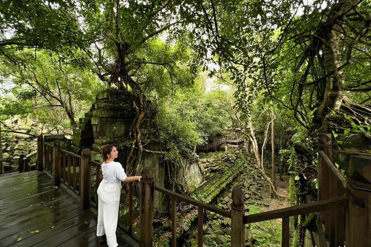 seorang lelaki berdiri di atas jambatan kayu berhampiran pagar