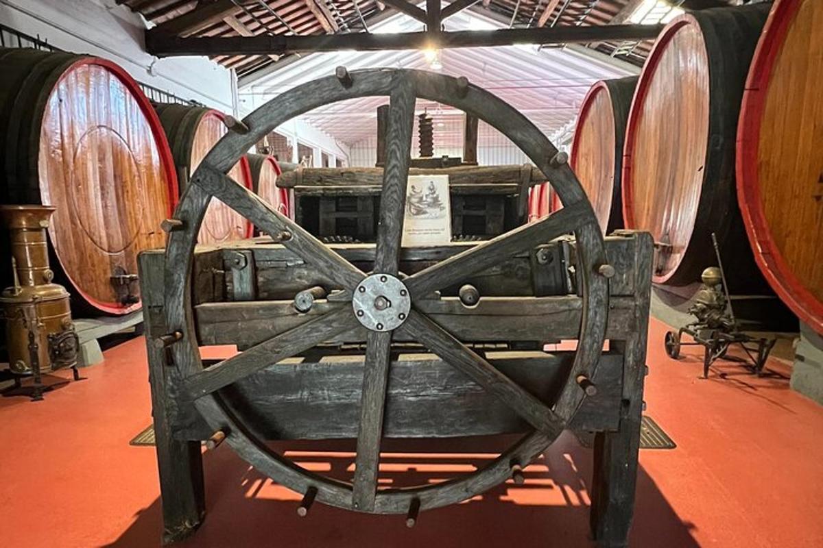 uma roda de madeira em uma sala com barris de vinho