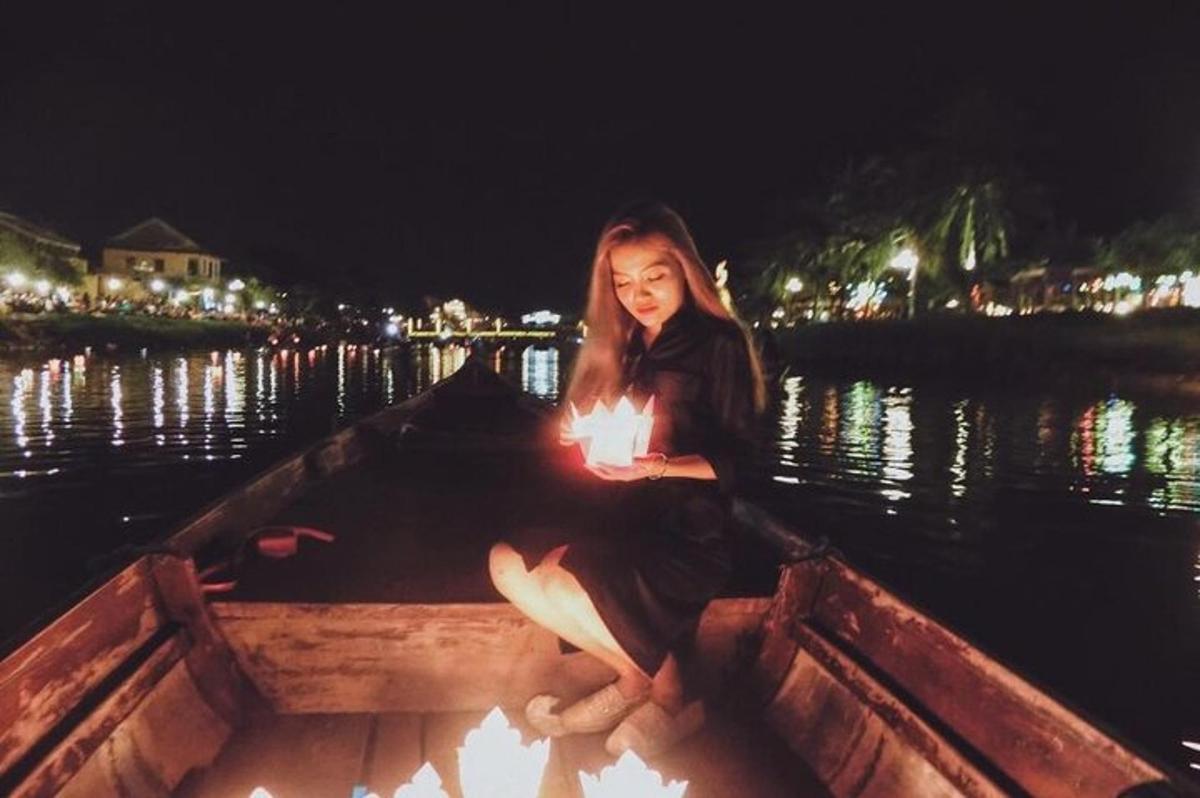 bir teknede mumla oturan bir kadın