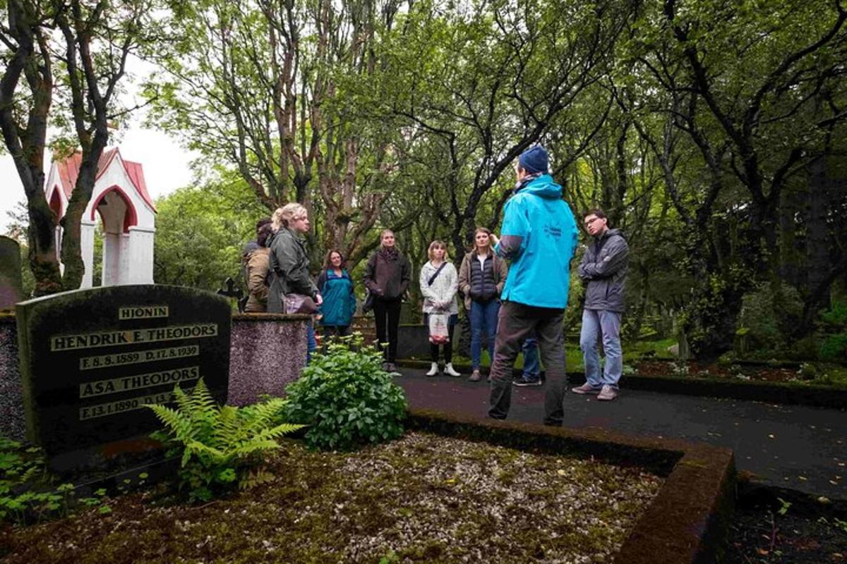Un grupo de personas paradas afuera de un cementerio.