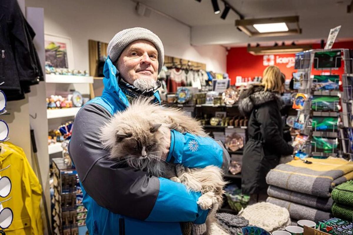 un uomo tiene in braccio un gatto in un negozio