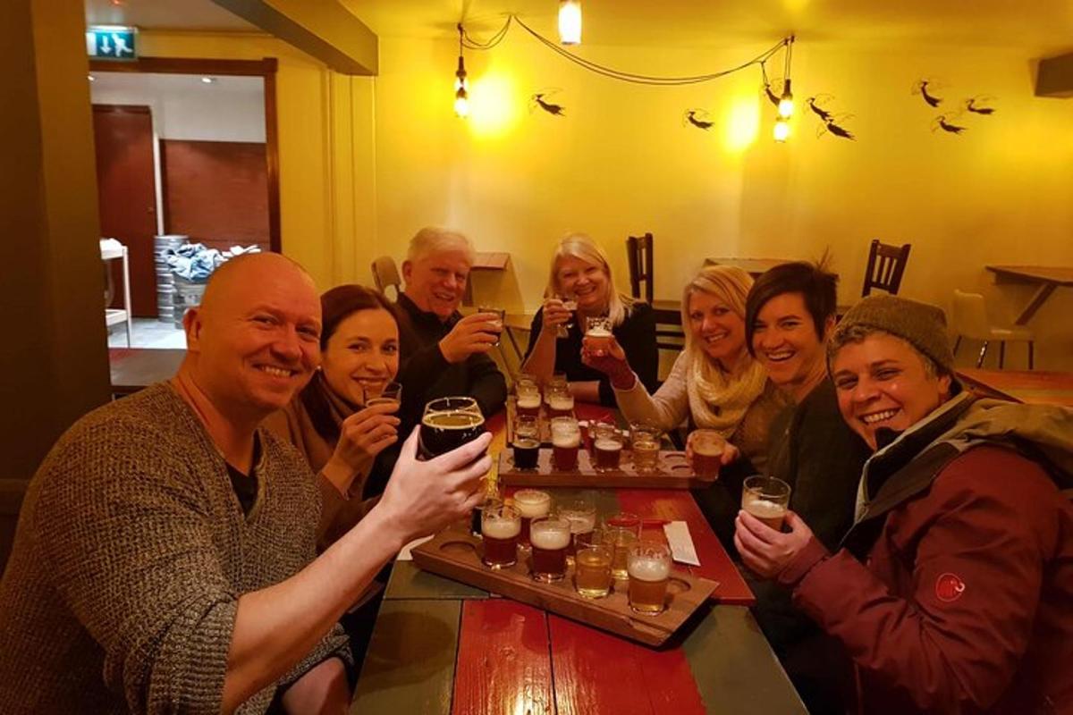Un grupo de personas sentadas en una mesa bebiendo cerveza