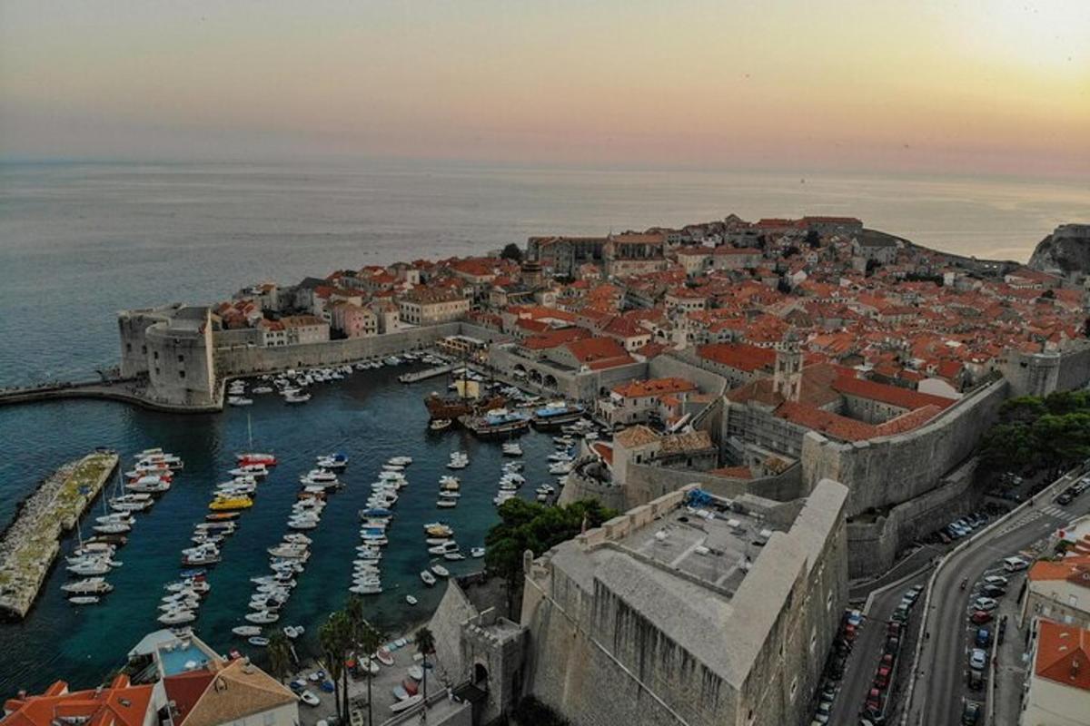 an aerial view of a city with boats in a harbor