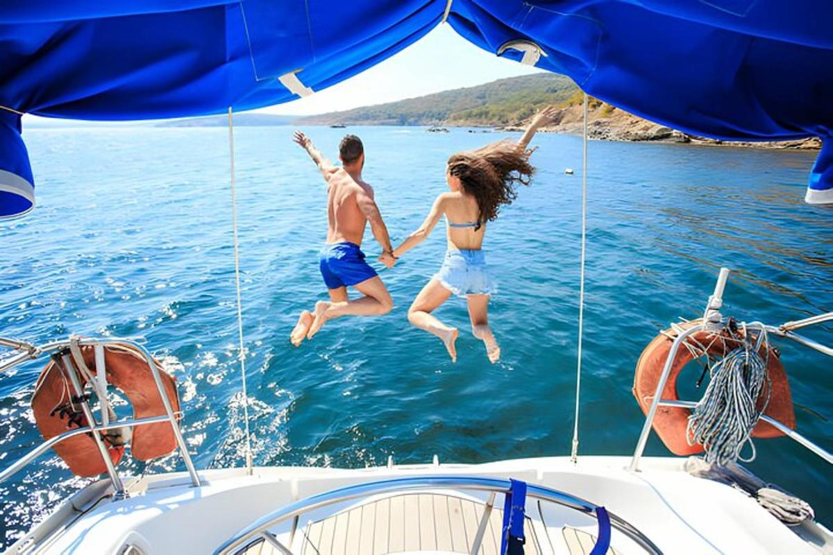two people jumping into the water from a boat