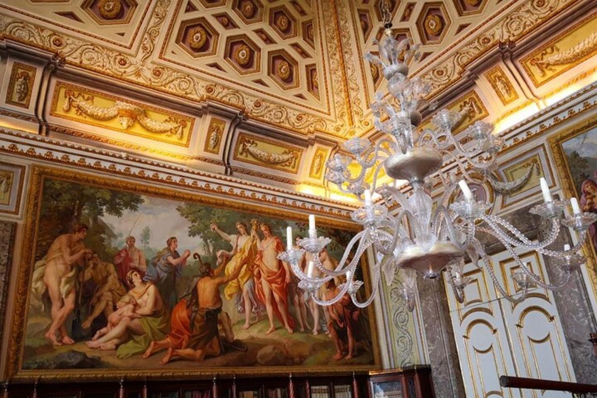 a chandelier in a room with a painting on the ceiling