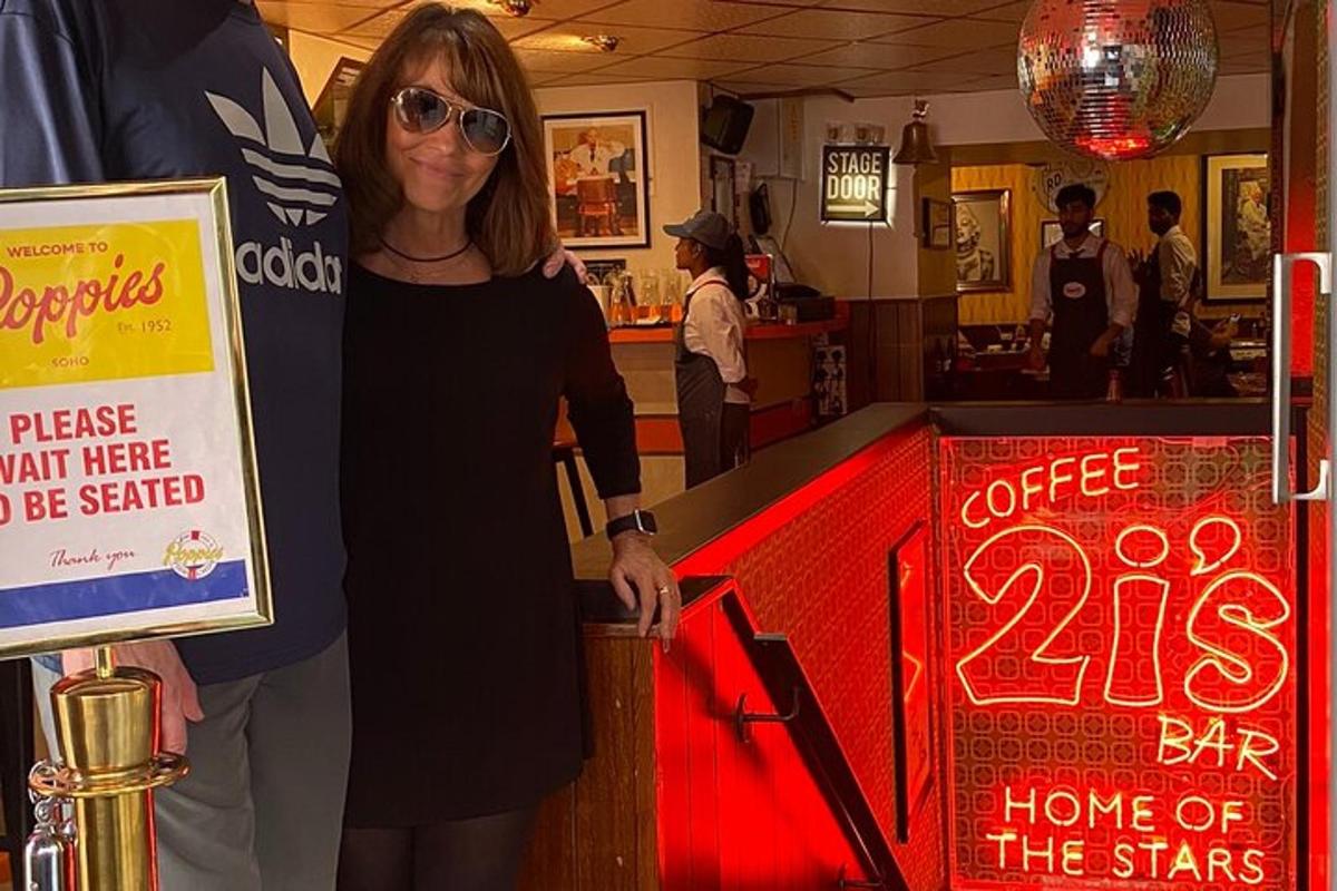 una dona dreta al costat d'un bar amb un rètol