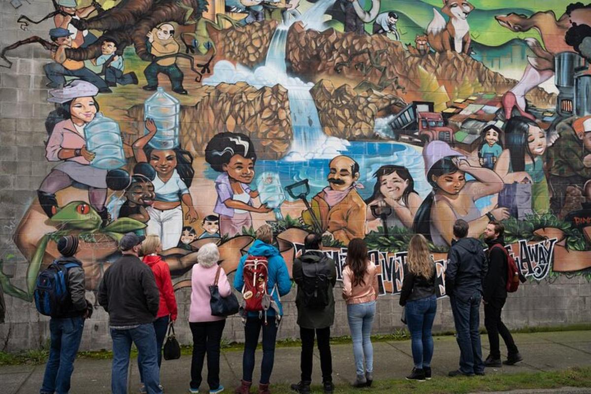 un groupe de personnes debout devant une peinture murale