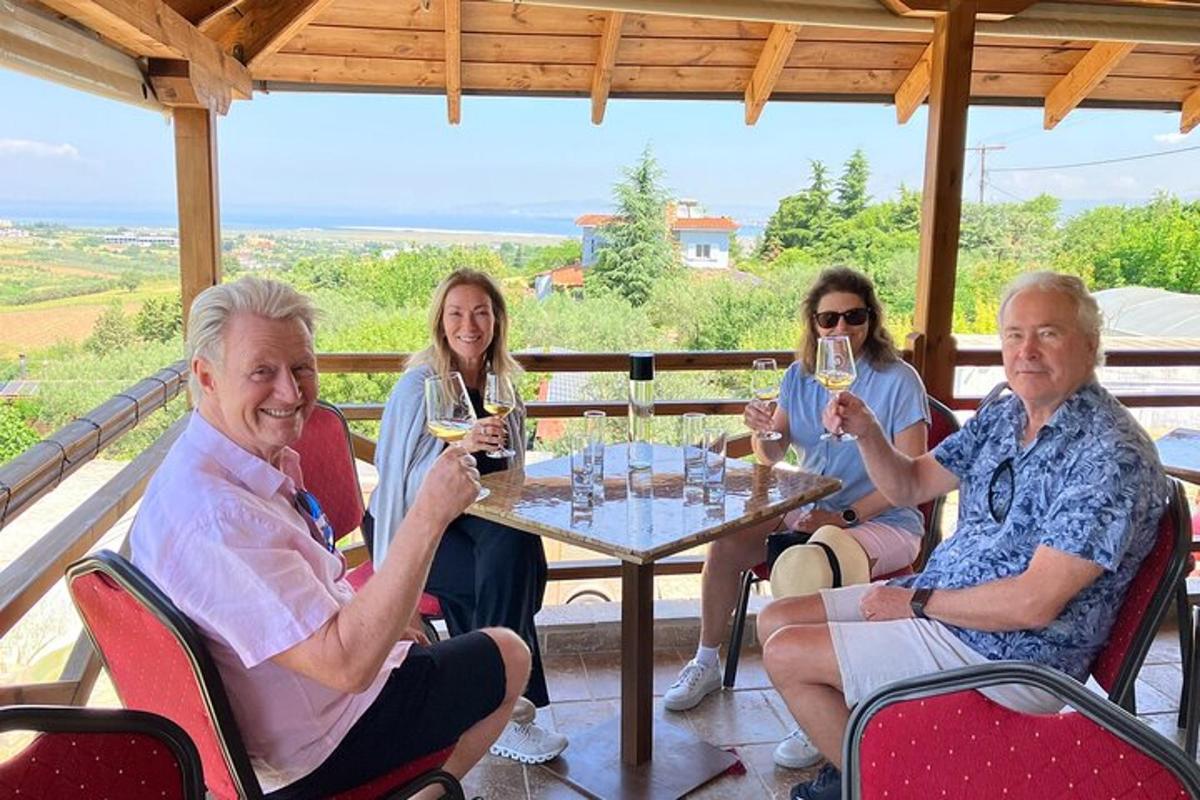 um grupo de pessoas sentadas ao redor de uma mesa bebendo vinho