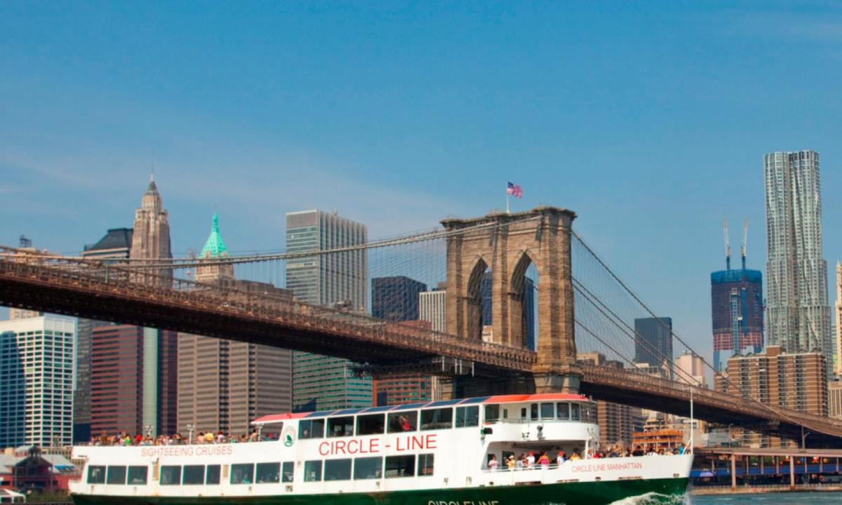 a cruise line boat passing under a bridge