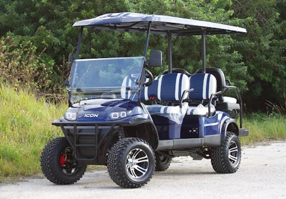 a blue golf cart parked on a dirt road