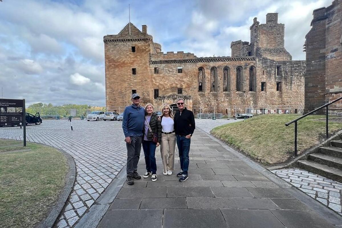 Un grupo de personas de pie frente a un castillo.