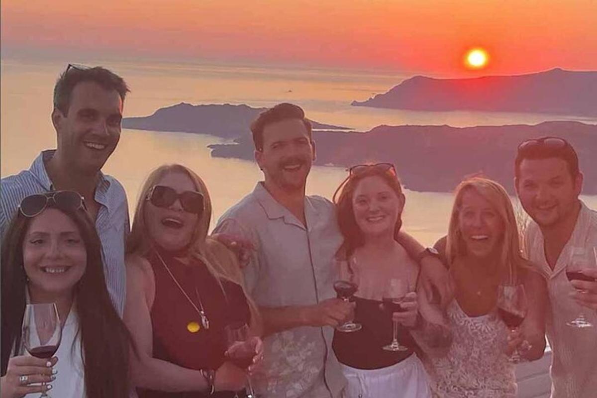 a group of people posing for a picture with wine glasses