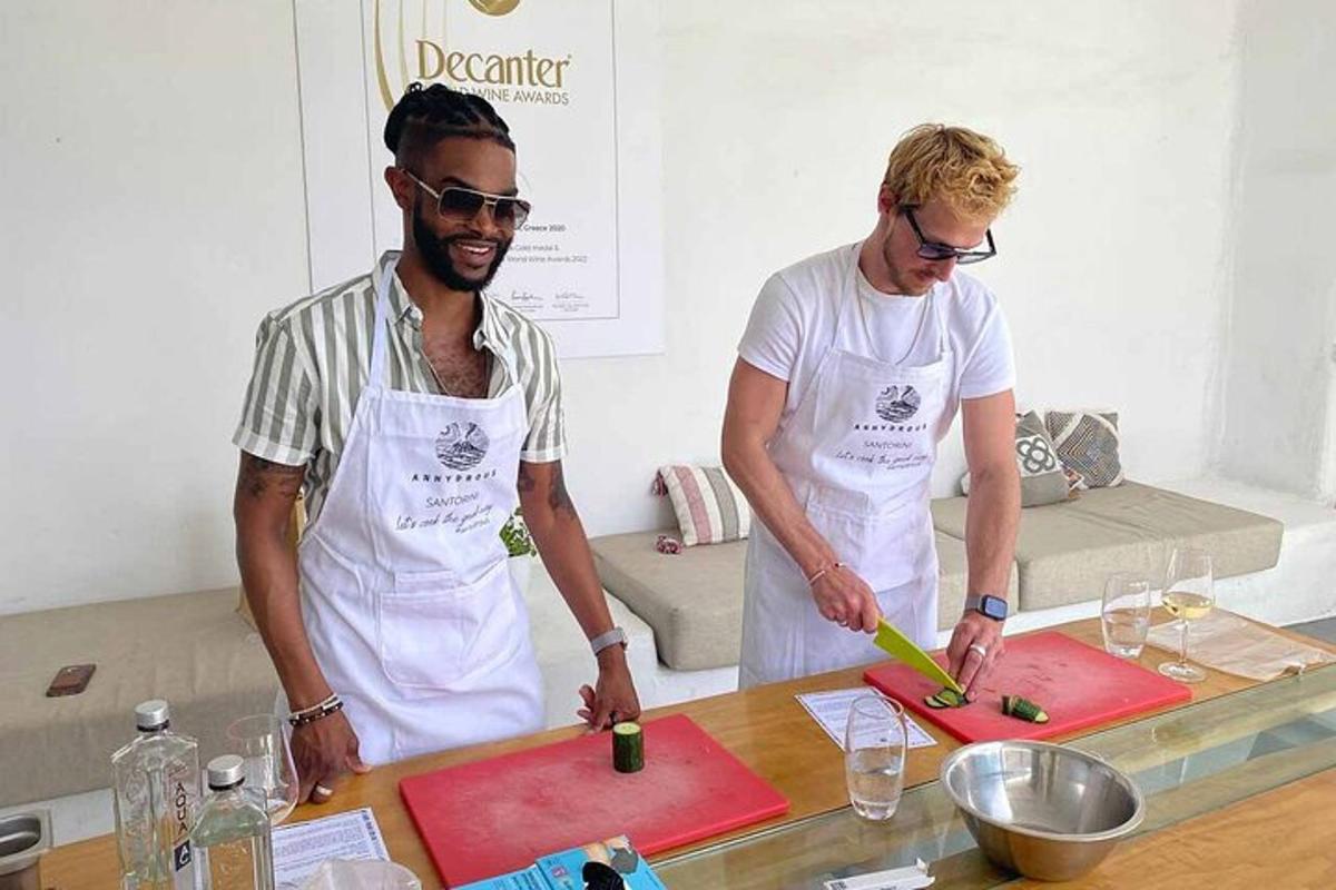 dois homens em uma cozinha preparando comida em tábuas de corte