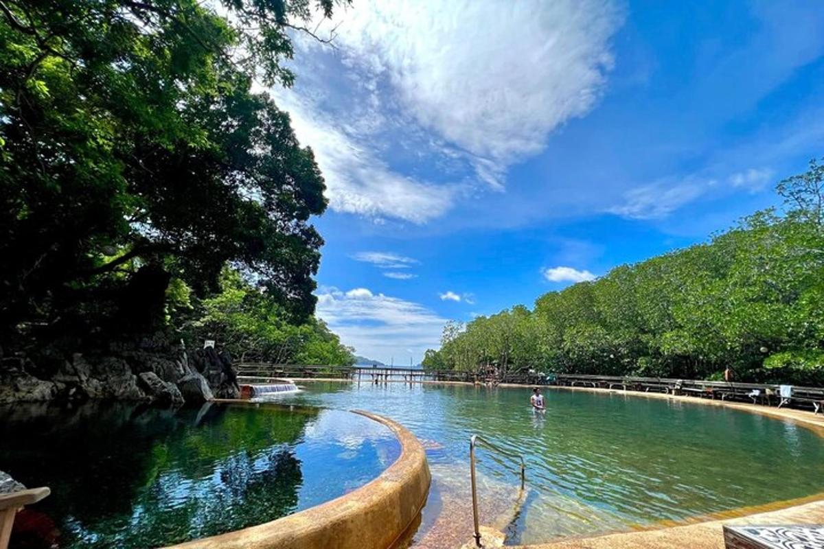 a large pool of water with trees and a blue sky