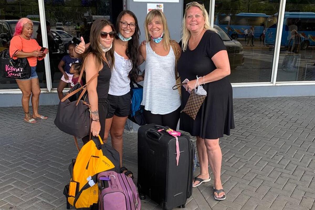 quattro donne posano per una foto con i loro bagagli
