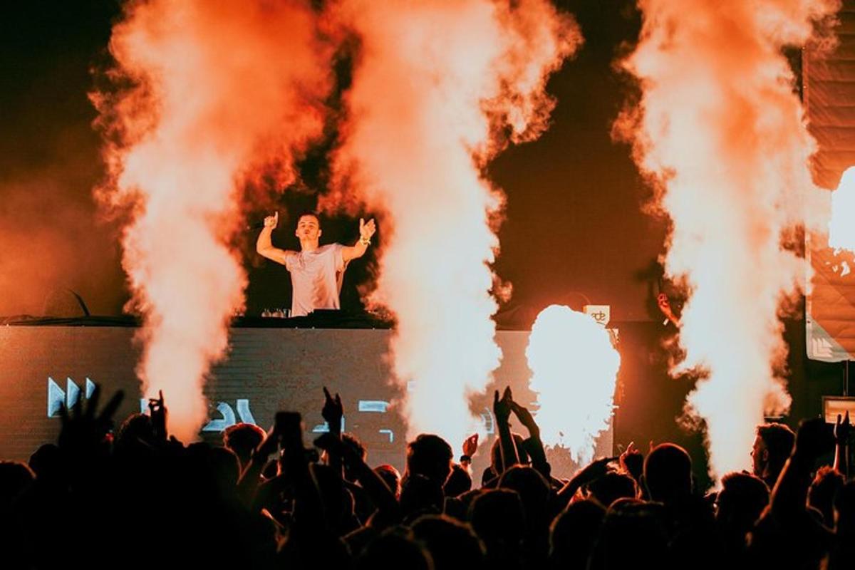 a crowd watches a man on the stage at a concert