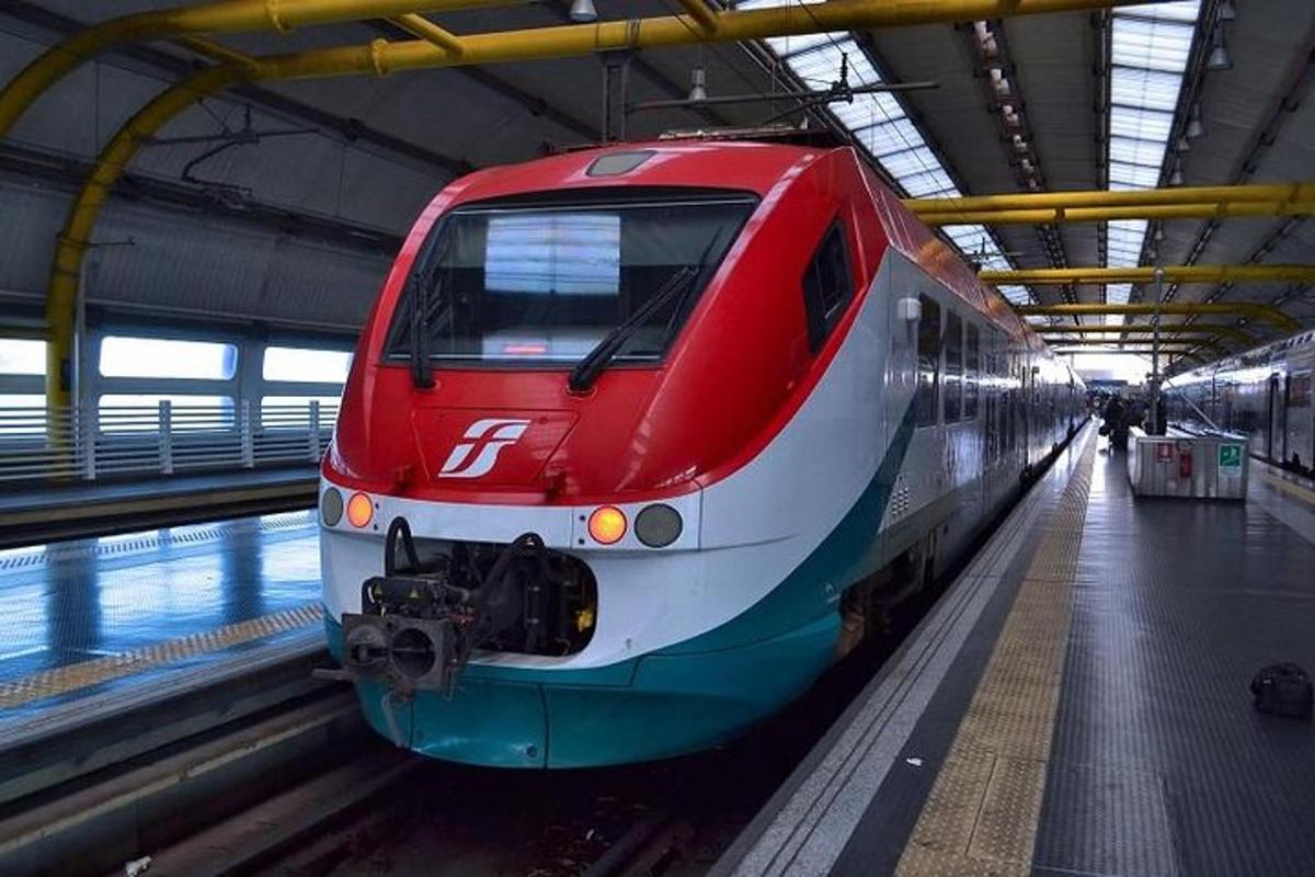 czerwony pociąg wjeżdża na stację kolejową