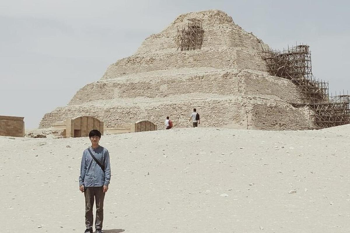 a boy standing in front of a pyramid